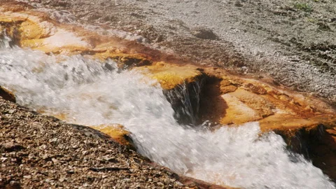 Slow motion hot water stream in volcanic geyser basic, iron and cooper mineral Video stock 161034283
