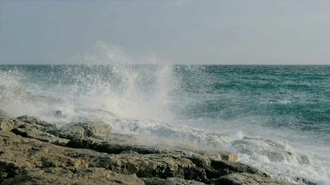 SLOW MOTION: huge sea waves splash on a rocky seashore view. Video stock 84025944