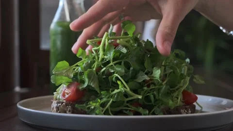Slow-motion of a human hand dropping green leaves on the healthy dietary vegan Video stock 166991710
