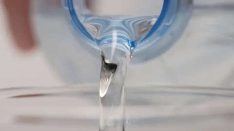 SLOW MOTION: Human hand pours a clear water from a plastic bottle Stock Footage 71568531