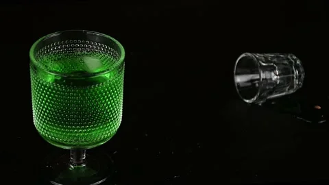 Slow motion ice being dropped into green drink for St Patrick's Day Stock Footage 231558360