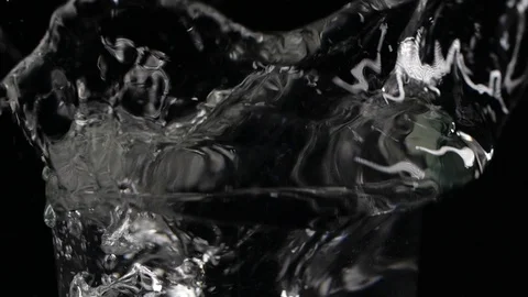 Slow motion ice cube falling down in a glass of water Stockbeeldmateriaal 123199045