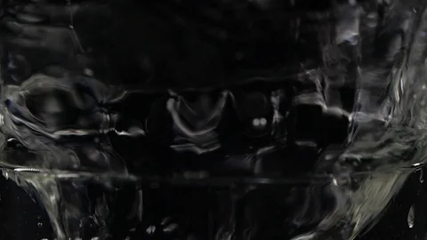 Slow motion ice cube falling down in a glass of water Stockbeeldmateriaal 123199070