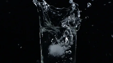 Slow motion ice cube falling down in a glass of water Vídeos de archivo 123199083