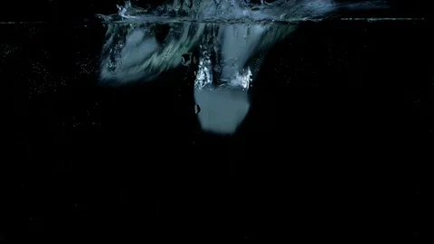Slow motion of ice cubes falling and splashing under water on black background Stock Footage 123222042