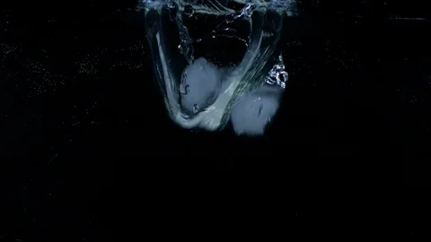 Slow motion of ice cubes falling and splashing under water on black background Vídeos de archivo 123222051
