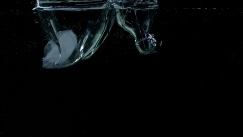 Slow motion of ice cubes falling and splashing under water on black background Vídeos de archivo 123222274