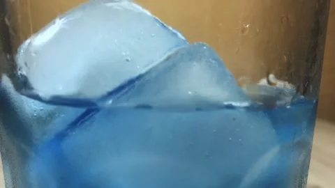 Slow motion ice cubes in glass. blue water Video stock 157002825