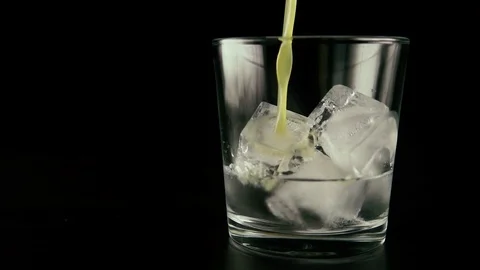 Slow motion. Ice with vodka in a glass to pour the juice Stock Footage 76434507