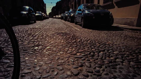 Slow motion image of a bicycle wheel rolling on cobblestones Stock Footage 274679691