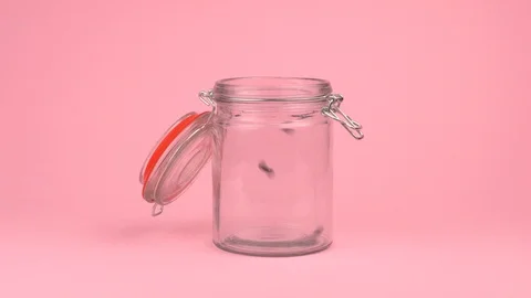 Slow motion image of black beans falling on jar glass over pastel background. Stock Footage 106807584