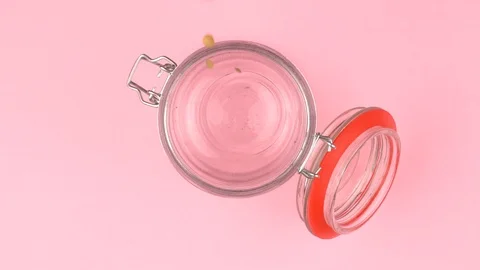 Slow motion image of lentils falling on jar glass over pastel background. Vídeo Stock 106806706