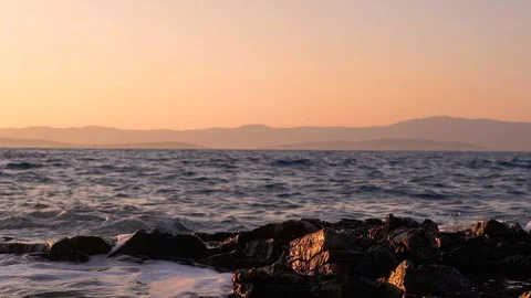Slow motion image of seawater breaking at shore during a scenic sunset, Croatia. Stock Footage 114685418