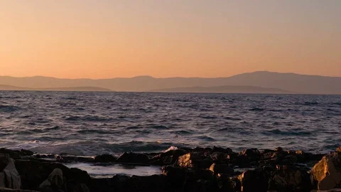 Slow motion image of seawater breaking at shore during a scenic sunset, Croatia. Stock Footage 114685576