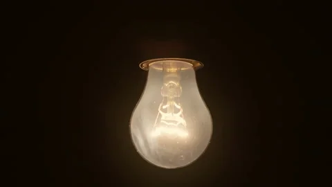 Slow motion of an incandescent light bulb tanning on a dark background Stock Footage 227519323