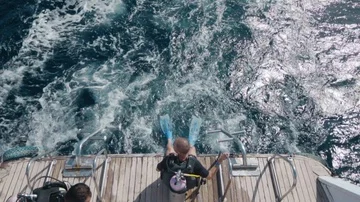 Slow motion An indistinguishable scuba diver sits on the edge of the boat. The Stock-Footage 86156683