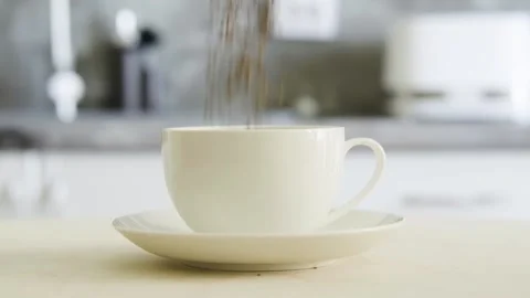 Slow motion. Instant black coffee drops into a white cup. 360-degree rotating Stock Footage 154708585