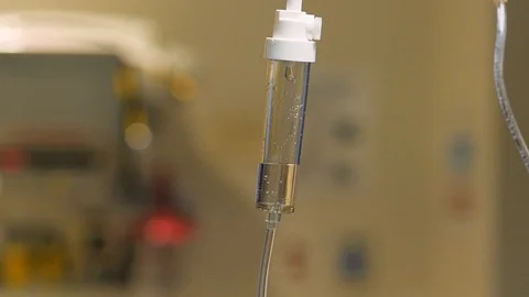 Slow motion iv drip close up with hopsital equipment in background Stock Footage 93667362
