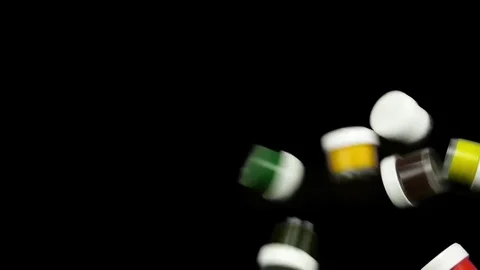 Slow motion jars of paint fall on smooth black background. 库存影片 84498713