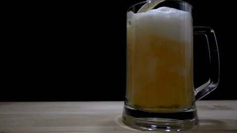 Slow motion of a jet of beer pouring into glass with space for text. Stock Footage 102932332