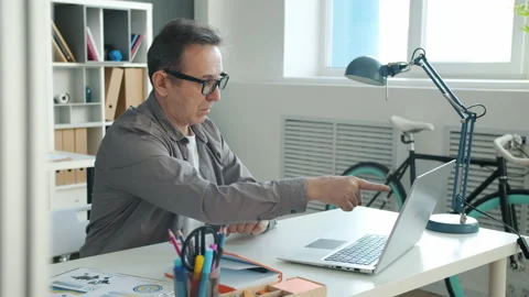 Slow motion of joyful man using computer pointing at screen laughing taking Stock Footage 142060376