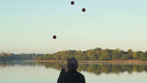 Slow-Motion Juggling overlooking Pond Video stock 101283144