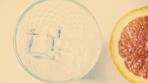 Slow motion juice being poured into a glass on the ice top view Stock Footage 72051132