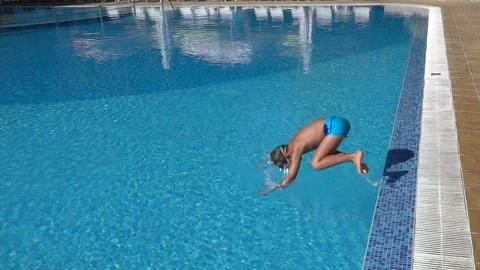 Slow motion jump into a swimming pool. Boy jumping into the water. Stock Footage 154407144