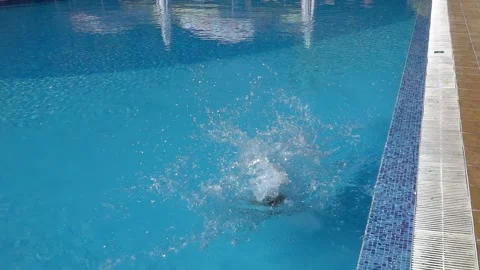 Slow motion jump into a swimming pool. Boy jumping into the water. Stock Footage 267666873