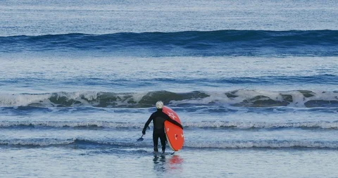 Slow motion of kayakers approaching the water at Morro Bay, Claifornia Stock Footage 99143595