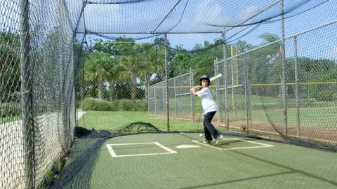 Slow motion of Kid batting at batting cages Stock Footage 85653643