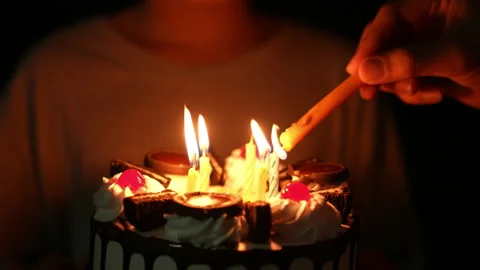 Slow motion kid blowing fire candle on cake of happy birth day cake on night 库存影片 236839915