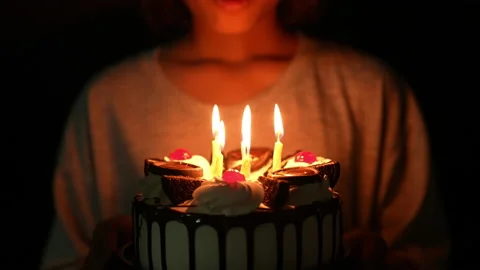 Slow motion kid blowing fire candle on cake of happy birth day cake on night Видео 236840309