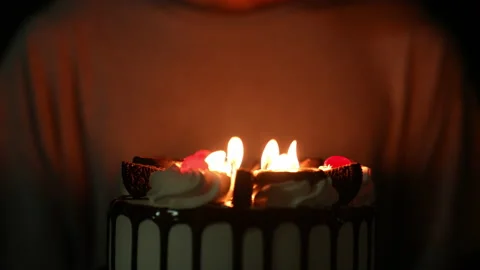 Slow motion kid blowing fire candle on cake of happy birth day cake on night Stock Footage 236840570