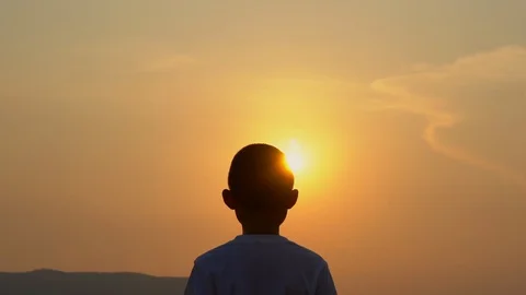 Slow motion kid boy playing exercising on morning sunrise sky background Stock Footage 129640287