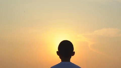 Slow motion kid boy playing exercising on morning sunrise sky background Stock Footage 129640294