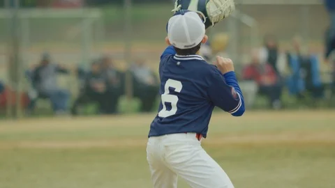Slow motion of a kid catching a ball during a baseball game Stock Footage 117075422