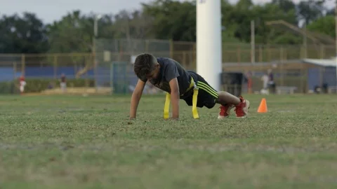 Slow motion of kid doing push ups while at flag football practice Stock Footage 92507926