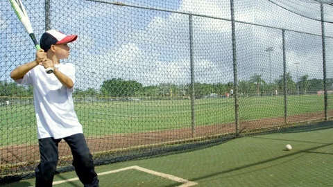 Slow motion of kid hitting ball inside batting cages at baseball park Stock Footage 85645644
