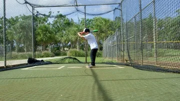 Slow motion of kid hitting bat inside batting cages at baseball park Stock Footage 85645203