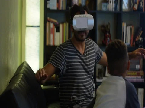 Slow motion of kid hugging his dad while dad plays with VR glasses Stock Footage 78490977