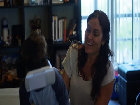 Slow Motion of kid passing Virtual Reality headset to his mom so she can play Stockbeeldmateriaal 78687586