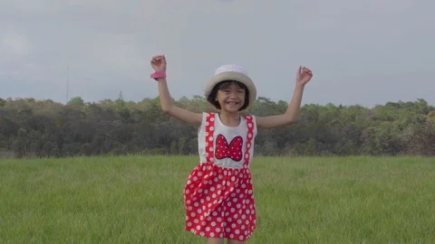 Slow motion kid playing and jumping on grassland pasture on hills and blue sky Video stock 112580594