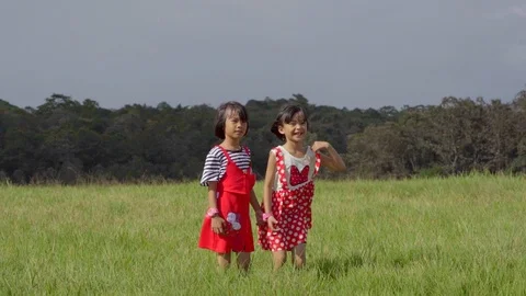 Slow motion kid playing and jumping on grassland pasture on hills and blue sky Video stock 112582495