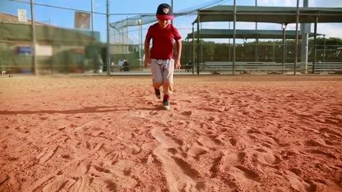 Slow Motion of kid running and sliding at first base at baseball field Stock Footage