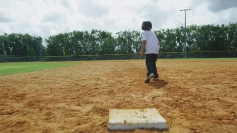 Slow Motion of kid running from first base, sliding at second at baseball park Stock Footage 85645789