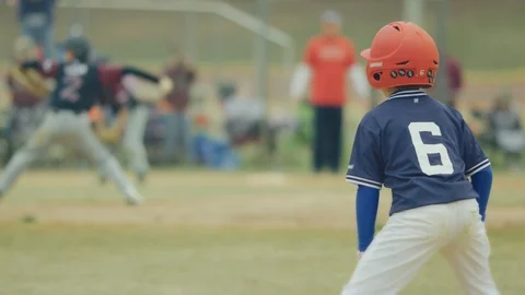 Slow motion of a kid running to second base during a baseball game Stock Footage 117076471