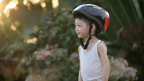 Slow motion, kid smile happy wearing helmet safety for riding bicycle Stock Footage