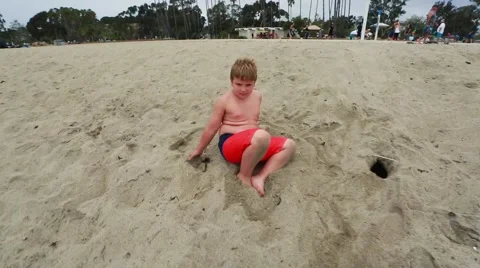 Slow motion of kid smiling at camera and playing at the beach Stock Footage 63749599