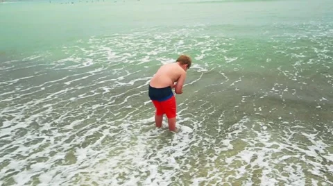 Slow motion of kid throwing sand into the ocean Stock Footage 63749519